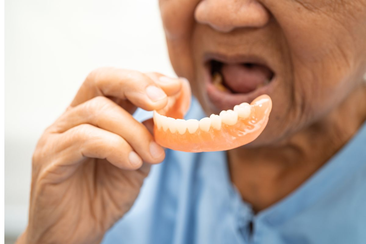 Senior person struggling with loose, ill-fitting dentures